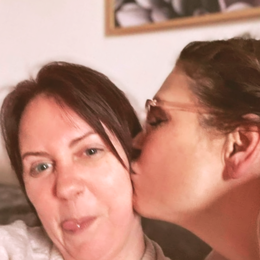 Christine från HerMine`s och hennes käraste vän i ett glatt ögonblick — ett kysst på kinden och ett skratt på väg ut. En bild från lyckligare dagar, buren med kärlek.