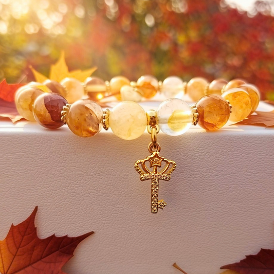 SEREN-armband mot höstlöv, gyllenbruna Golden Healer-pärlor och en hängande nyckelberlock i guld med cubic zirconia
